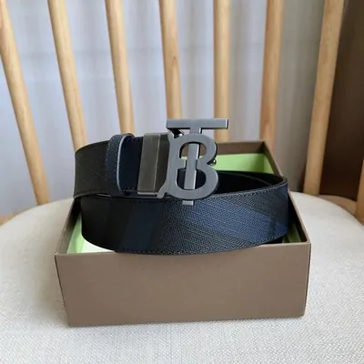 A black leather belt with a gold buckle, shown in its box